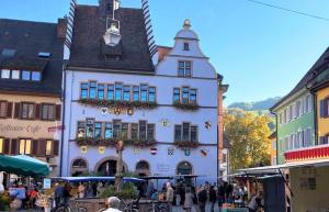 a group of people walking in front of a white building at Ferienwohnung Belchenblick in Staufen im Breisgau