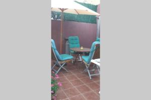 um pátio com cadeiras, uma mesa e um guarda-sol em Apartamento vacaciones em Palafrugell