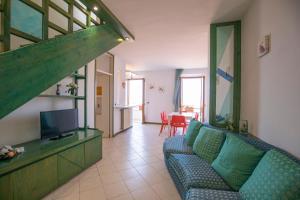 a living room with a couch and a television at Casa il tramonto in Capoliveri