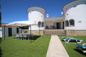 una casa con césped con sillas y mesa en Villa Paradis, en Miami Platja