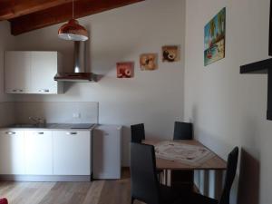 een keuken met een tafel, een wastafel en een koelkast bij B&B LE AGAVI in Borso del Grappa