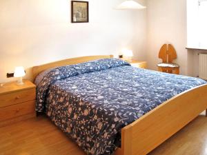 a bedroom with a bed with a blue comforter at Apartment Giuditta by Interhome in Pera +11 photos
