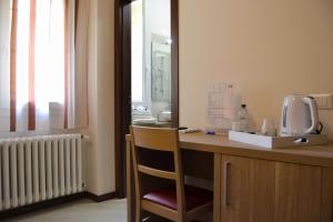 Cette chambre comprend un bureau avec une chaise et un miroir. dans l'établissement Palazzo Liberty BnB, à Bologne