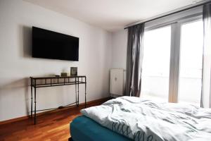 ein Schlafzimmer mit einem Bett und einem Flachbildfernseher in der Unterkunft Dorya am Ring in Köln