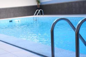ein Schwimmbad mit blauem Wasser in einem Gebäude in der Unterkunft Executives Hotel - Azizia in Riad