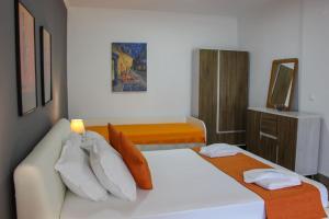 a bedroom with a white bed and a couch at Mirador Apartments in Limenas