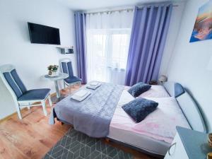 Villa Róża pokoje & apartamenty في ليبا: غرفة نوم بسرير وطاولة ونافذة