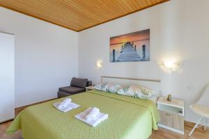 ein Schlafzimmer mit einem grünen Bett und Handtüchern darauf in der Unterkunft Rooms Sani in Brela