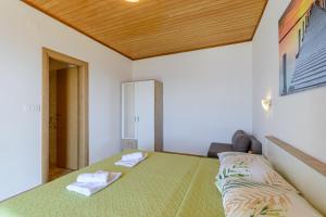 ein Schlafzimmer mit einem Bett mit zwei Handtüchern darauf in der Unterkunft Rooms Sani in Brela