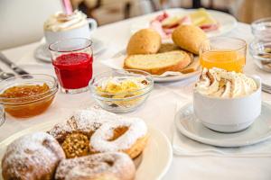 une table garnie de assiettes de pâtisseries et de boissons dans l'établissement Hotel Ambasciatori, à Bellaria-Igea Marina