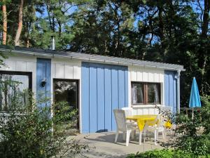 ヒンメルプフォルトにあるHoliday Home Waldhäuser-1 by Interhomeの青と白の小屋(テーブルと椅子付)