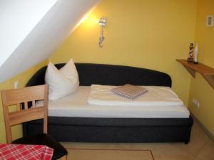 オストゼーバート・カールスハーゲンにあるHoliday Home Heide by Interhomeの黄色い壁の客室の小さなベッド1台分です。