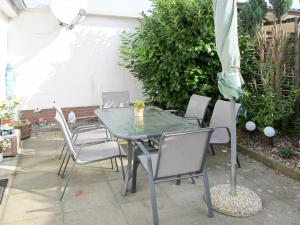 a table with chairs and an umbrella on a patio at Holiday Home Bella by Interhome in Hohen Wieschendorf