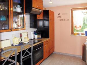 a kitchen with wooden cabinets and a counter top at Holiday Home Bella by Interhome in Hohen Wieschendorf