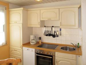 a kitchen with white cabinets and a sink at Holiday Home Am Walde-2 by Interhome in Dobbertin