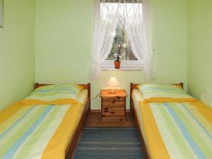 two beds in a small room with a window at Holiday Home Am Walde-2 by Interhome in Dobbertin