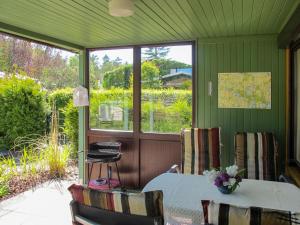 a screened in porch with a table and chairs at Holiday Home Am Walde-2 by Interhome in Dobbertin