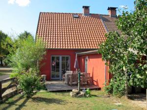 a red house with a deck in front of it at Holiday Home Kapitänshaus Leo by Interhome in Leopoldshagen