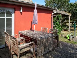 a wooden table with two chairs and an umbrella on a deck at Holiday Home Kapitänshaus Leo by Interhome in Leopoldshagen