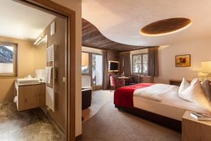 a hotel room with a bed and a desk at Almhotel Glieshof in Malles Venosta