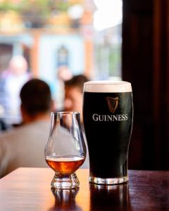 Una pinta de cerveza y un vaso en una mesa. en Thirteen On The Green - Eyre Square, en Galway