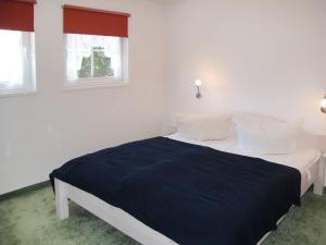 ツィノヴィッツにあるHoliday Home Schneider by Interhomeの白い部屋のベッド1台 窓2つ付