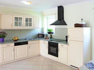 a kitchen with white cabinets and black appliances at Holiday Home Ferienpark Verchen-1 by Interhome in Verchen
