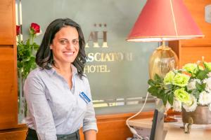 une femme debout devant un bureau avec une lampe dans l'établissement Hotel Ambasciatori, à Bellaria-Igea Marina