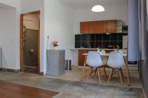 a kitchen with two white chairs and a table at Mirador Apartments in Limenas +49 photos