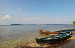 two boats sitting on the shore of a body of water at садиба ТУГАН-ДВІР in Svityazʼ
