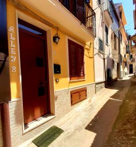 budynek z czerwonymi drzwiami na ulicy w obiekcie Alley 8 w mieście Scilla