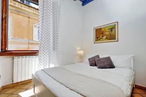 een slaapkamer met een wit bed en een raam bij Lungaretta 97 in Rome