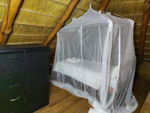 Bett in einem Zimmer mit Moskitonetz in der Unterkunft Chicuanga in Chizavane