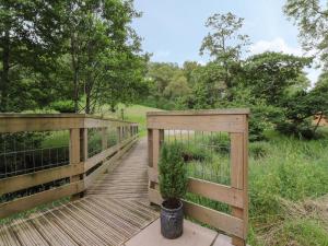 a wooden bridge with a potted plant on it at Park Brook Retreat in Scorton