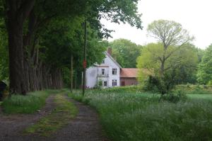 uma estrada de terra em frente a uma casa branca em Zöllnerhaus Nordhorn em Nordhorn