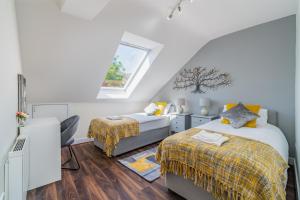 a attic bedroom with two beds and a window at Beautiful Flat Town Centre 55 inch Smart TV + Netflix in Andover