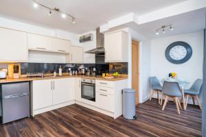 a kitchen with a table and a clock on the wall at Beautiful Flat Town Centre 55 inch Smart TV + Netflix in Andover