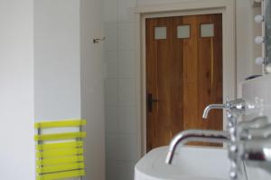 uma casa de banho com um lavatório e uma porta de madeira em Zöllnerhaus Nordhorn em Nordhorn