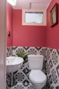La salle de bains est pourvue de toilettes blanches et d'un lavabo. dans l'établissement Athens Parrot, à Athènes