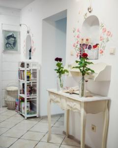 Różany Dworek في بستشستا كوودزكا: غرفة بها طاولة بيضاء عليها زهور