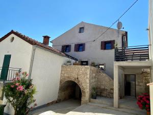 un gran edificio blanco con un arco delante de él en Relax Home Funtana, en Funtana