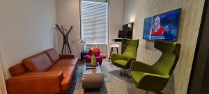 フランクフルト・アム・マインにあるホテル クリスタル - フランクフルト シティのリビングルーム(ソファ、椅子、薄型テレビ付)