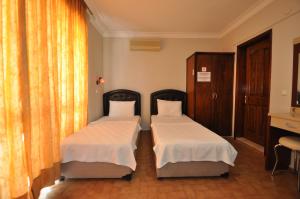 Postel nebo postele na pokoji v ubytování Defne & Zevkim Hotel
