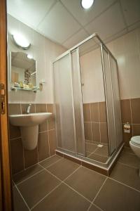 a bathroom with a shower, toilet and sink at Avcilar Vizyon Hotel in Istanbul