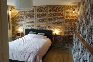 um quarto com uma cama numa parede de tijolos em Gîtes le second à Spa (gîte de 2 et de 5 personnes) em Spa