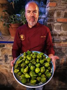 un hombre sosteniendo un gran tazón de limas verdes en Agriturismo Zio Cristoforo, en Casal Velino