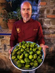 a man holding a large bowl of green limes at Agriturismo Zio Cristoforo in Casal Velino