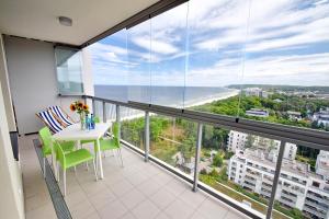 a balcony with a table and chairs and a view of the ocean at Apartamenty Onyx SeaView by Rent like home in Międzyzdroje