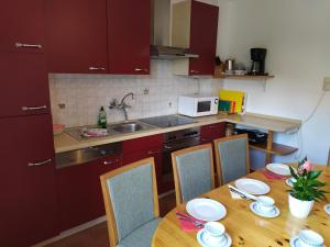 eine Küche mit einem Holztisch mit Stühlen und einem Waschbecken in der Unterkunft Appartement Ahornegger in Schladming