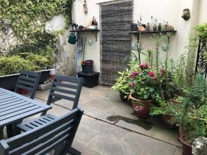 a patio with a table and chairs and plants at Larkin House in Rye
